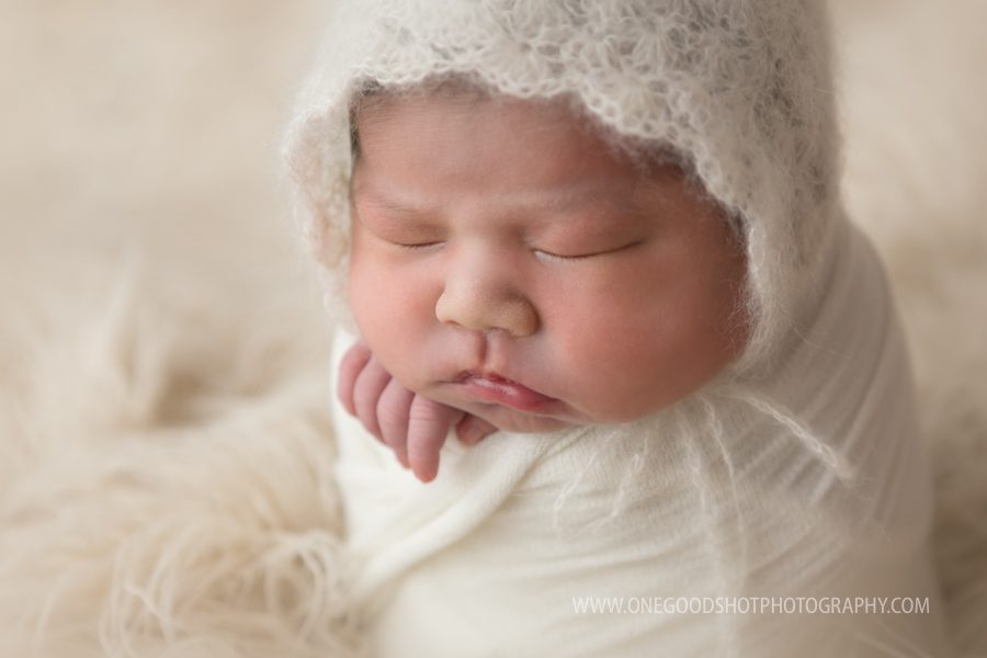 Newborn girl with vintage bonnet, potato sack pose