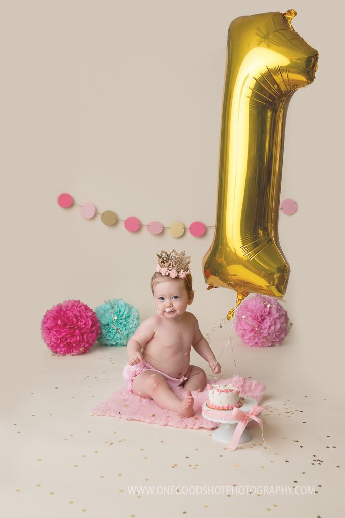 cake smash session, pink, teal, gold, one year old girl wearing princess crown