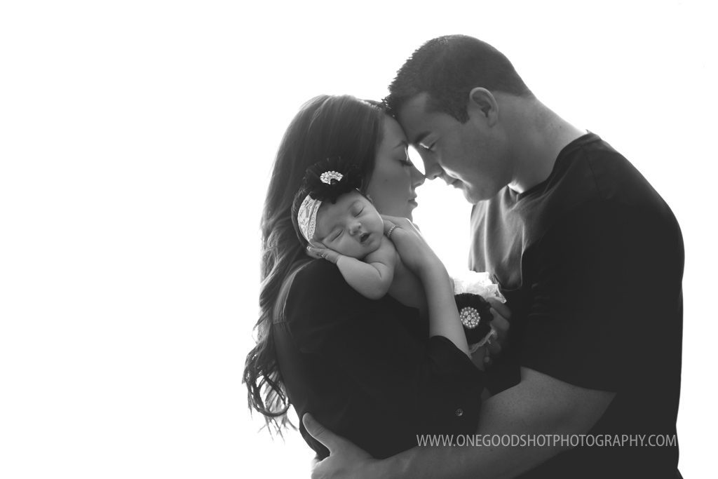 new parents, mommy, daddy, holding newborn girl, backlit, black and white image 