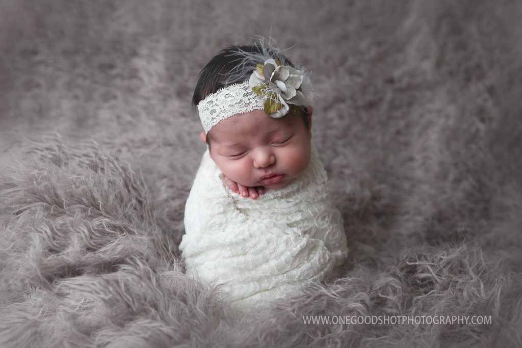newborn girl, potato sack pose, wrapped in white, gray fluff background