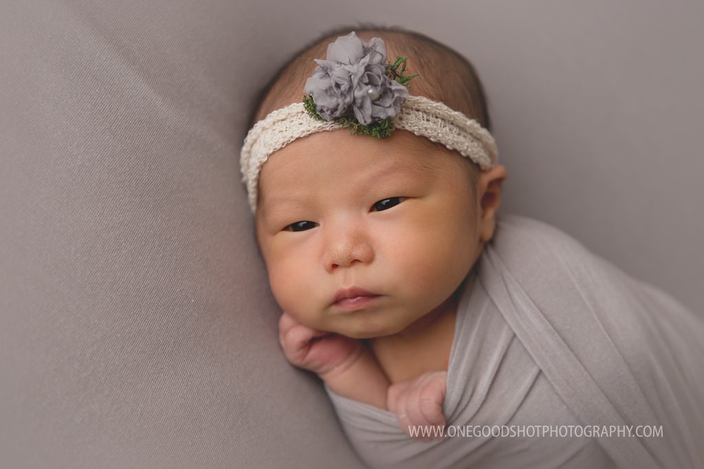 newborn girl awake wrapped in gray on a gray backdrop ,fresno photographer