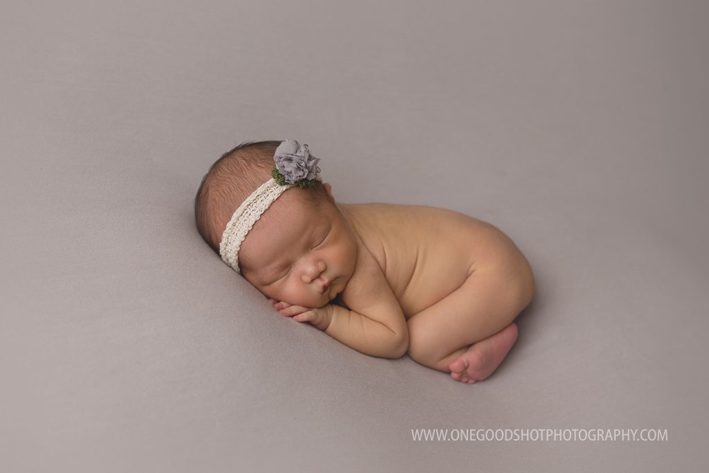 newborn girl in the bum up pose on a gray backdrop fresno photographer