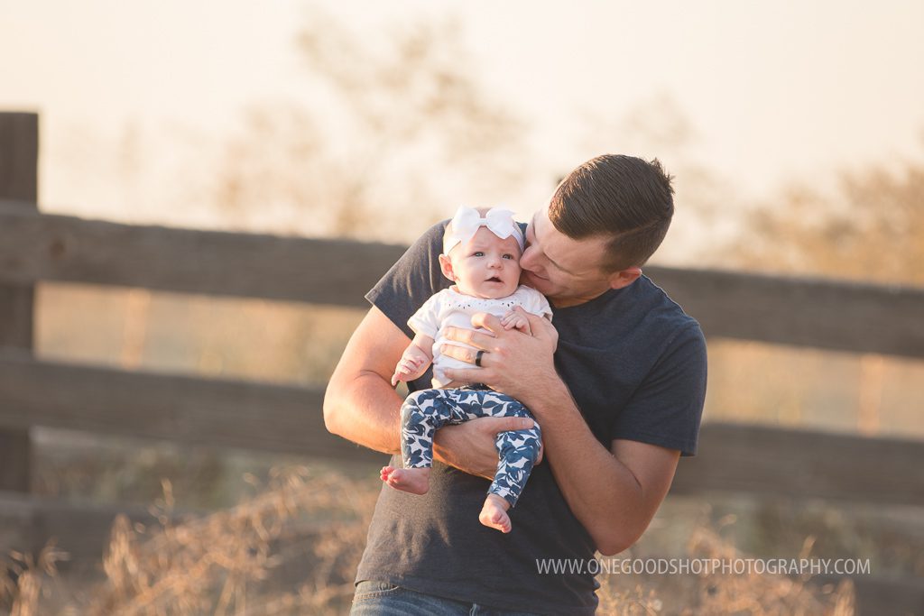Daddy holding baby girl in a wheat grass field, backlit, fresno family photographer
