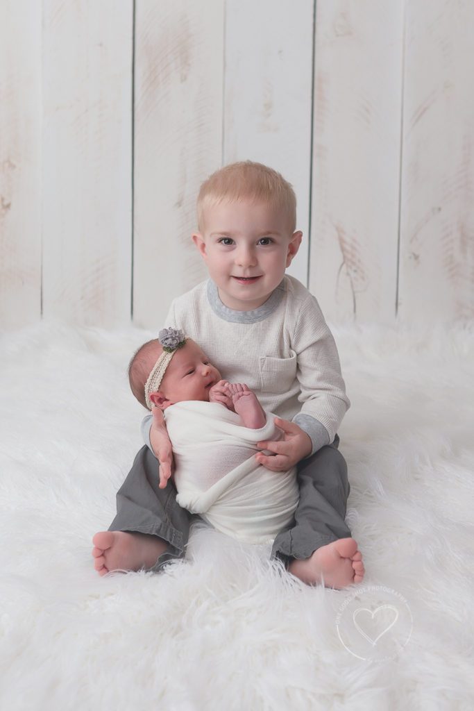 Brother holding newborn sister