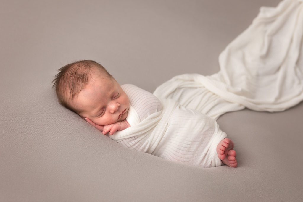 Fresno Newborn Photographer, One Good Shot Photography, Newborn Boy, Side Lying, Gray backdrop, Cream wrap