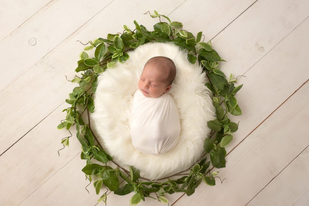 Fresno Newborn Photographer, One Good Shot Photography, Newborn Boy, Newborn Posing, White, Greenery, Baby wrapped in prop