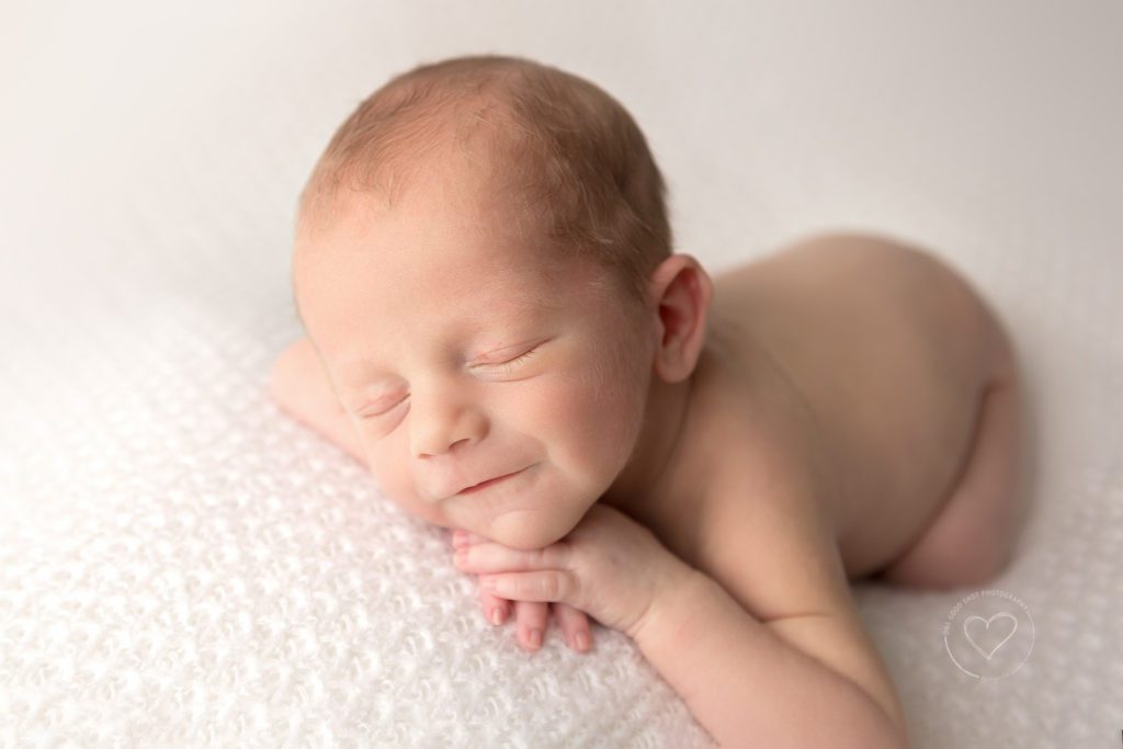 Newborn baby photographer, fresno, clovis, newborn twin boy, head on hands, smiling