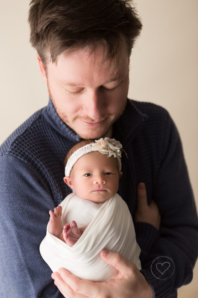 New dad holding newborn girl in arms