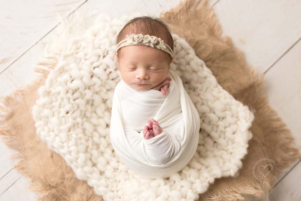 Newborn baby girl, wrapped in white floral headband, neutral layers, Fresno newborn photographer