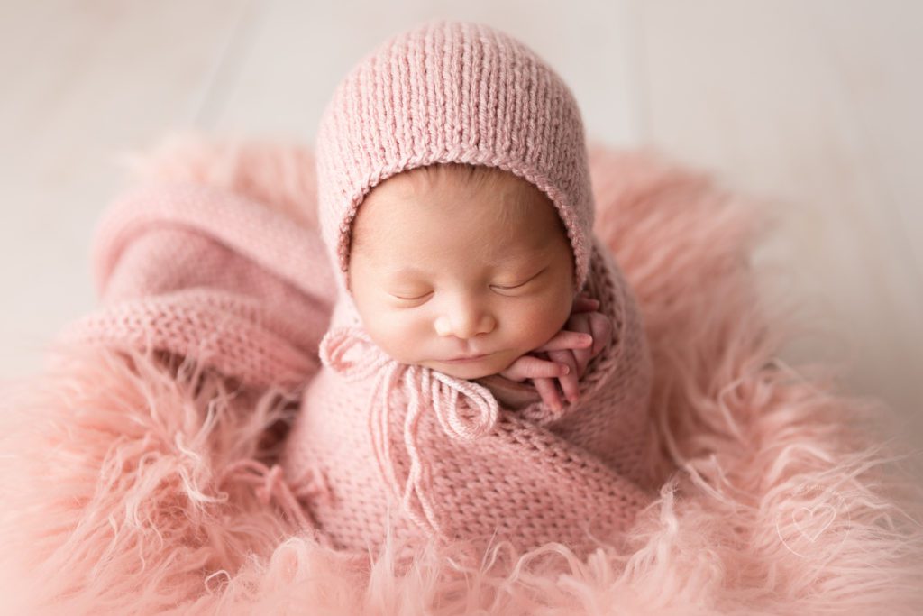 Fresno newborn photographer, baby girl, wrapped in pink wearing pink bonnet, potato sack pose