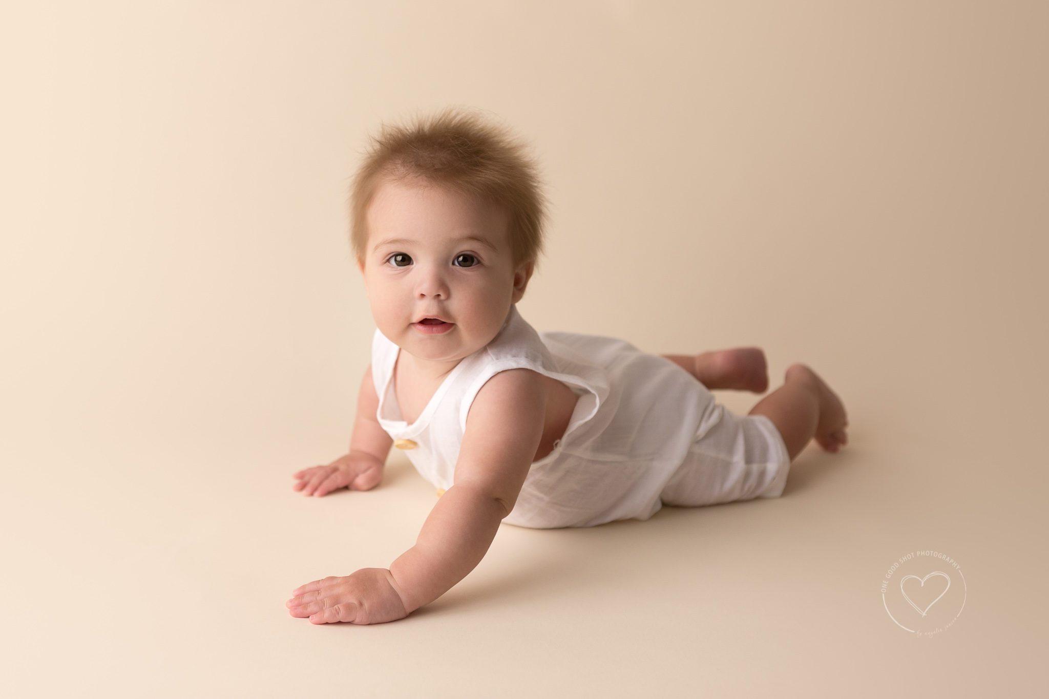 baby boy, 6 months old, sitter, lying on tummy, wearing white linen romper, Fresno baby photographer