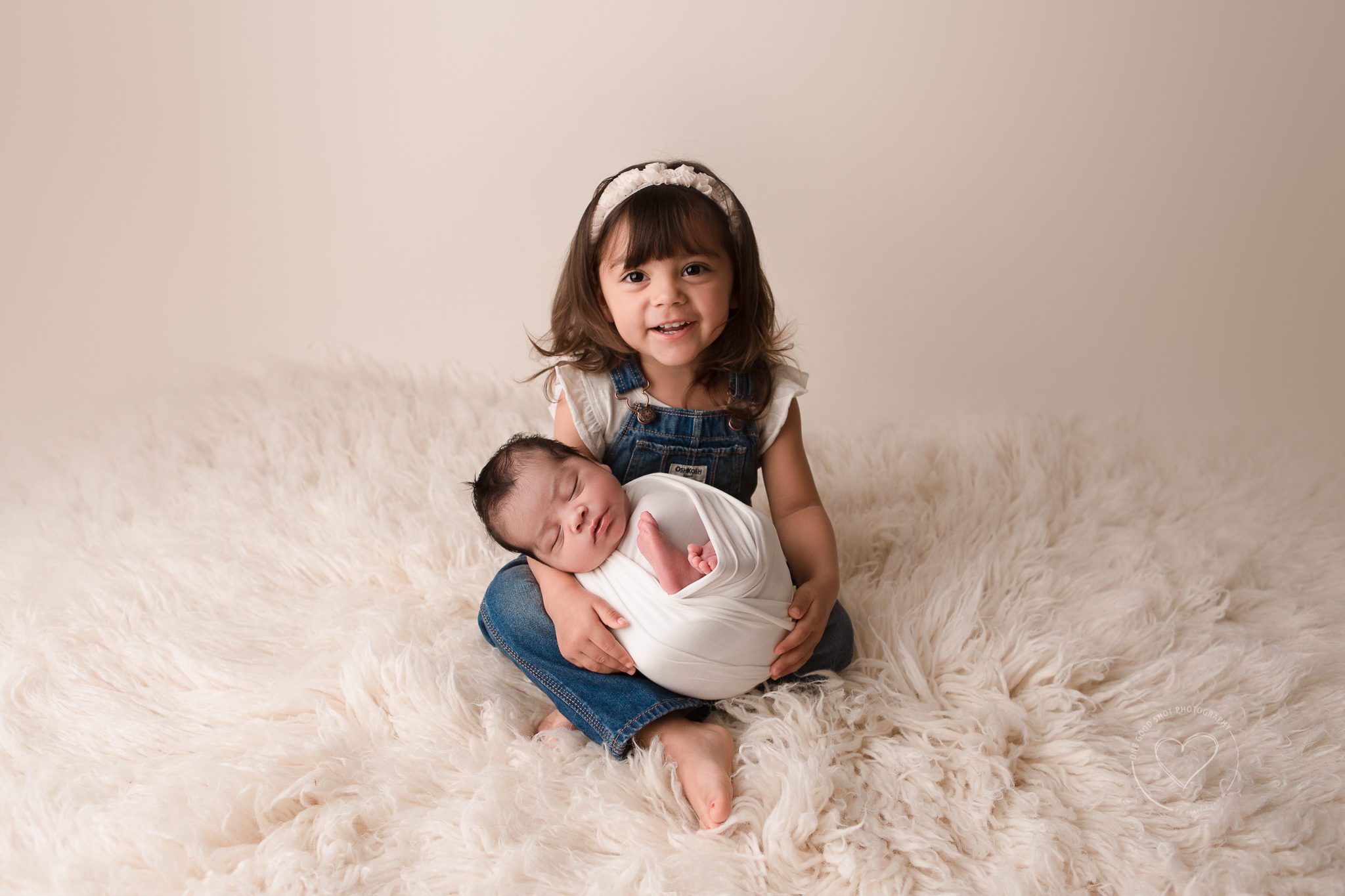 big sister holding newborn brother, smiling, Fresno, photographer