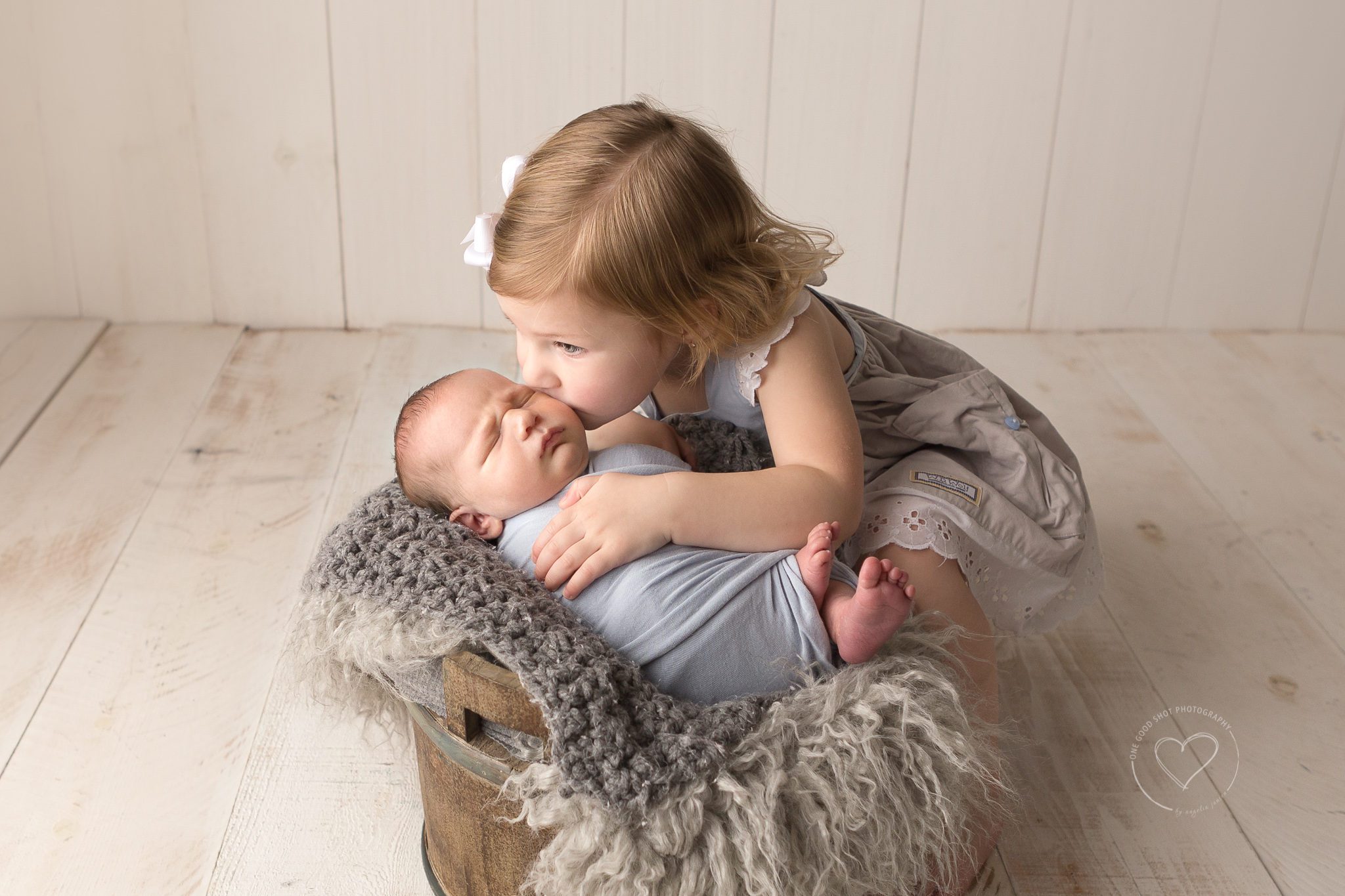 big sister kissing newborn brother in a bucket, Fresno, coves, photographer