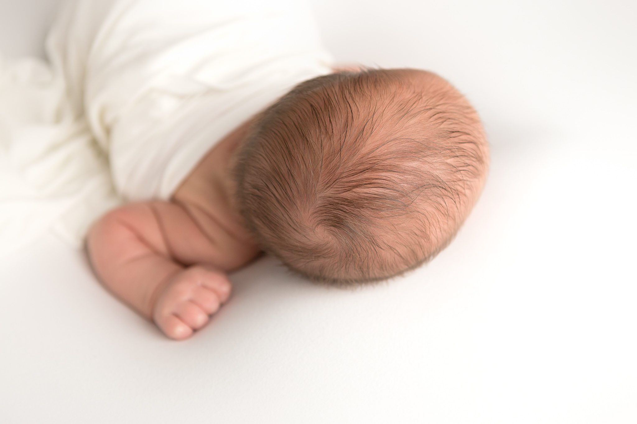 Newborn boy, photo of hair and hand, white background