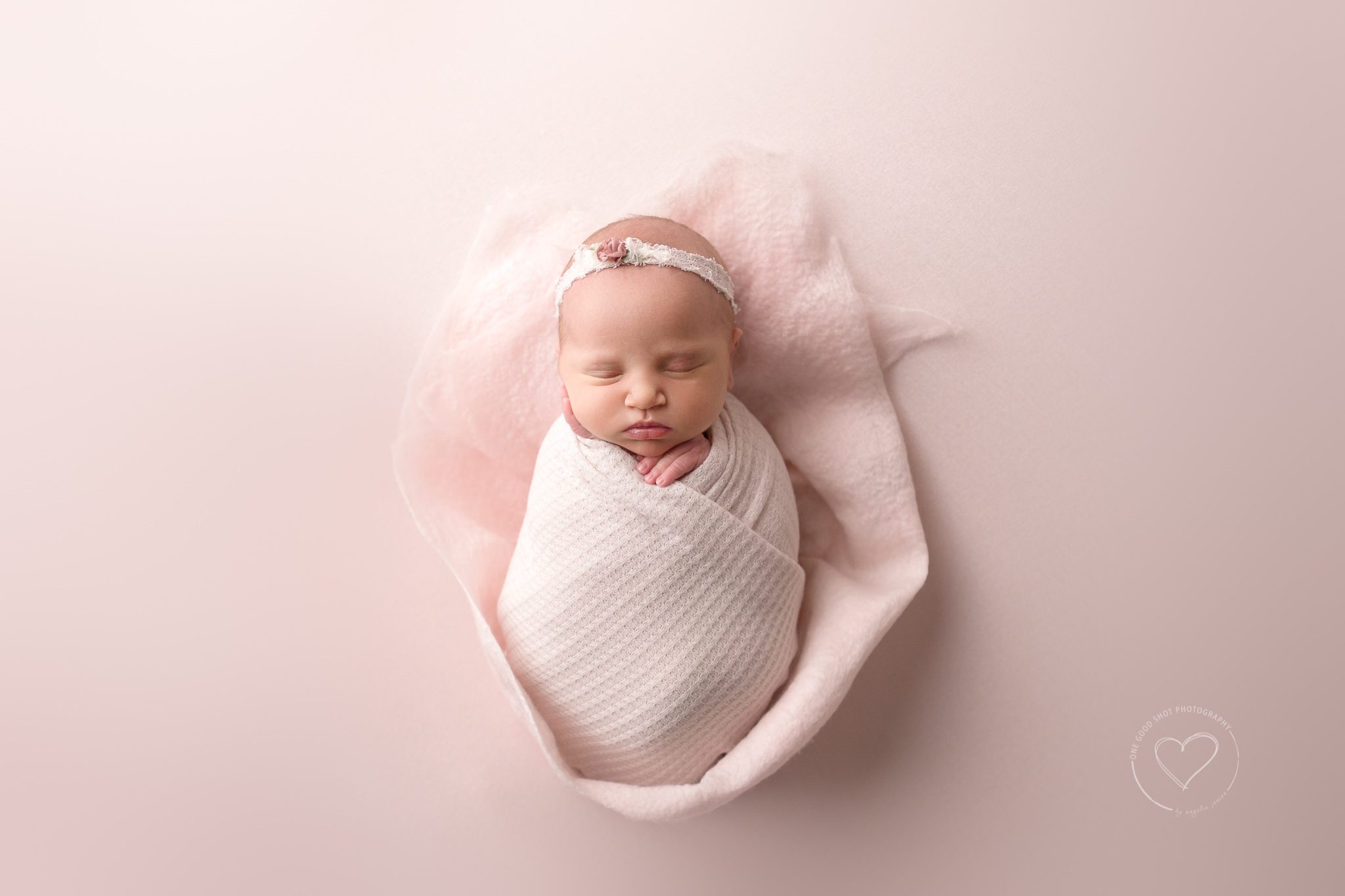 Fresno Newborn Photographer, Baby girl, wrapped in pink, wool rose petal layer, floral headband, pink background