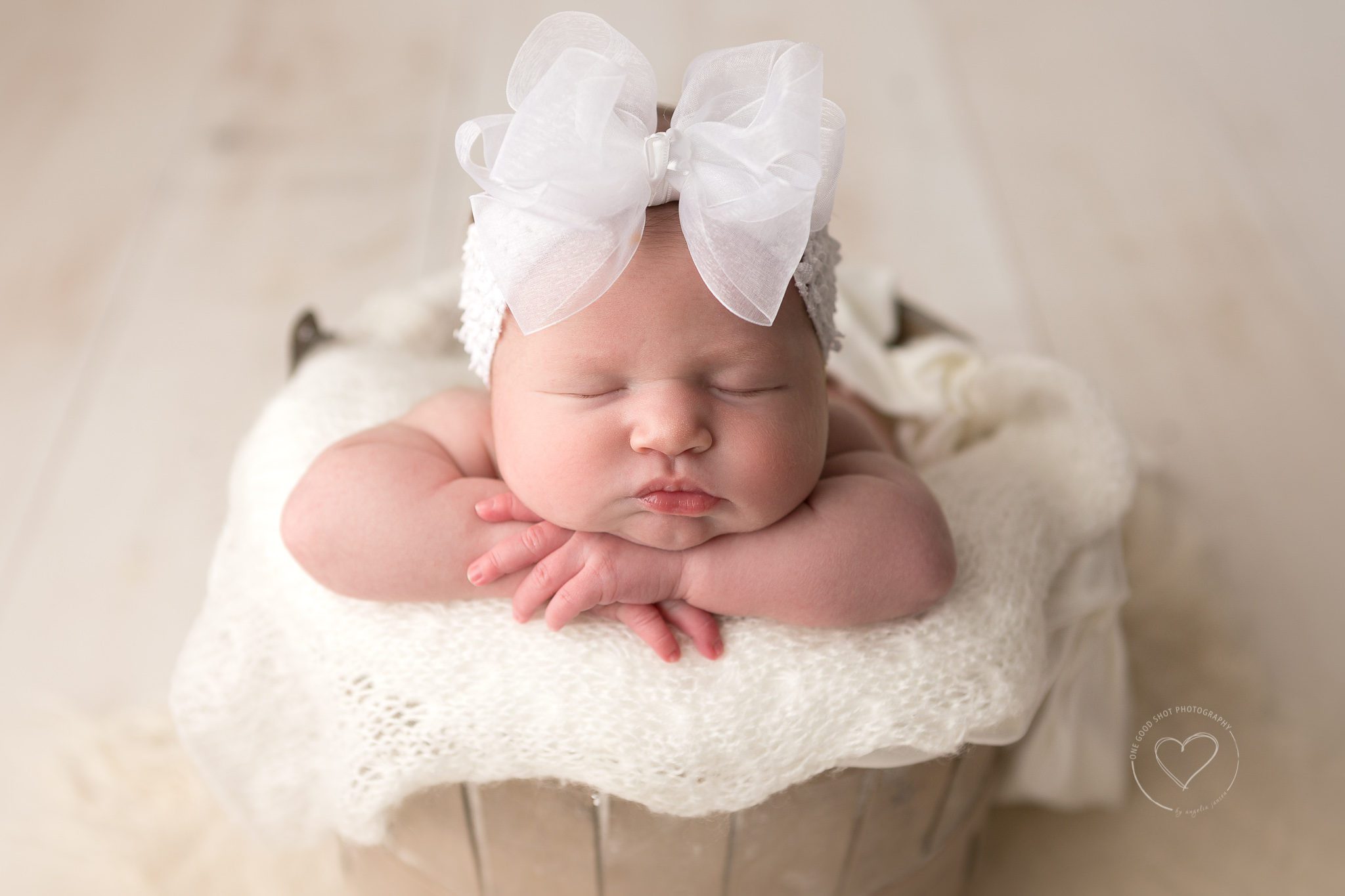 newborn girl, head on hands in a bucket, vintage bucket, white overlay,  big white bow