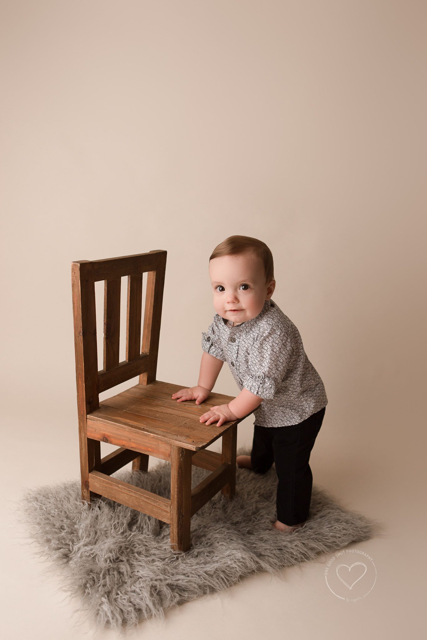 Fresno baby photographer, boy standing, holding onto small brown chair