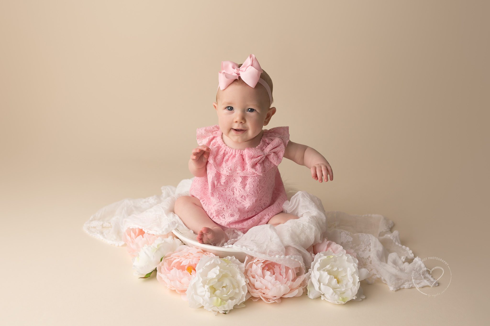 fresno, clovis, photographer, baby, girl, pink romper, pink bow, white fur, 6 months, sitter, flowers