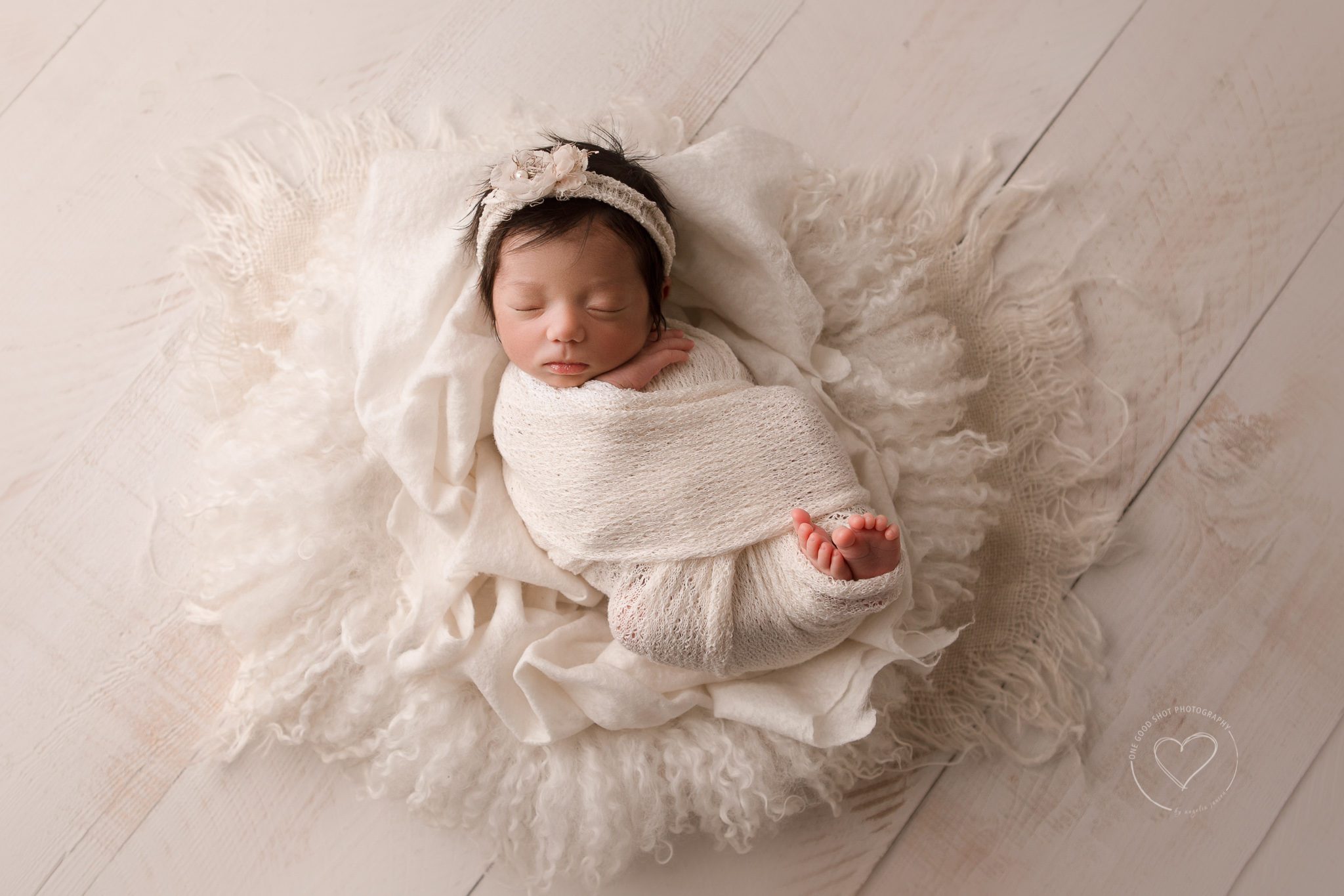 Fresno newborn photographer, wood backdrop, newborn girl wrapped in white lying in a bowl with white layers