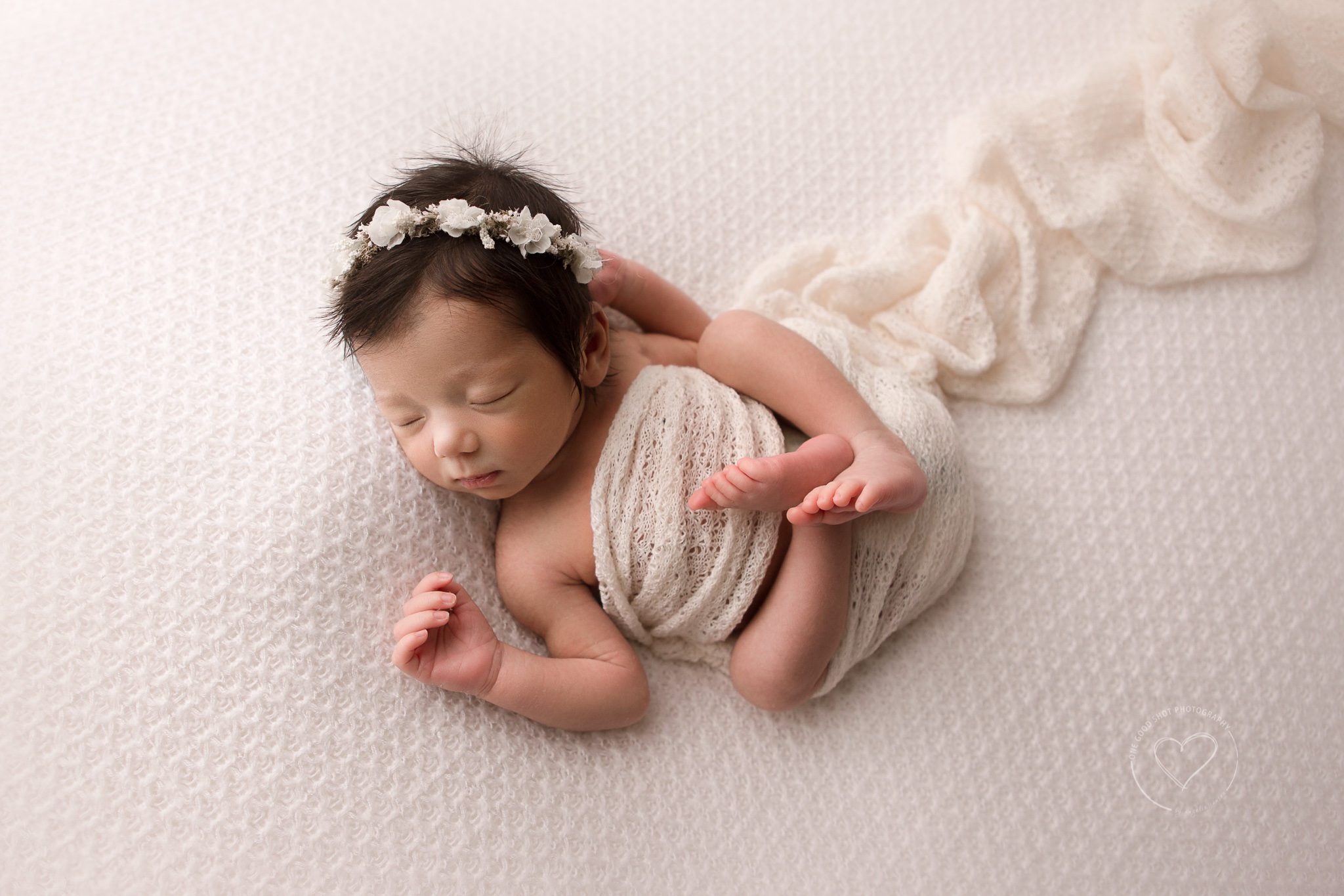 Fresno Newborn Photographer, huck finn pose from above, baby girl smiling, wearing floral halo