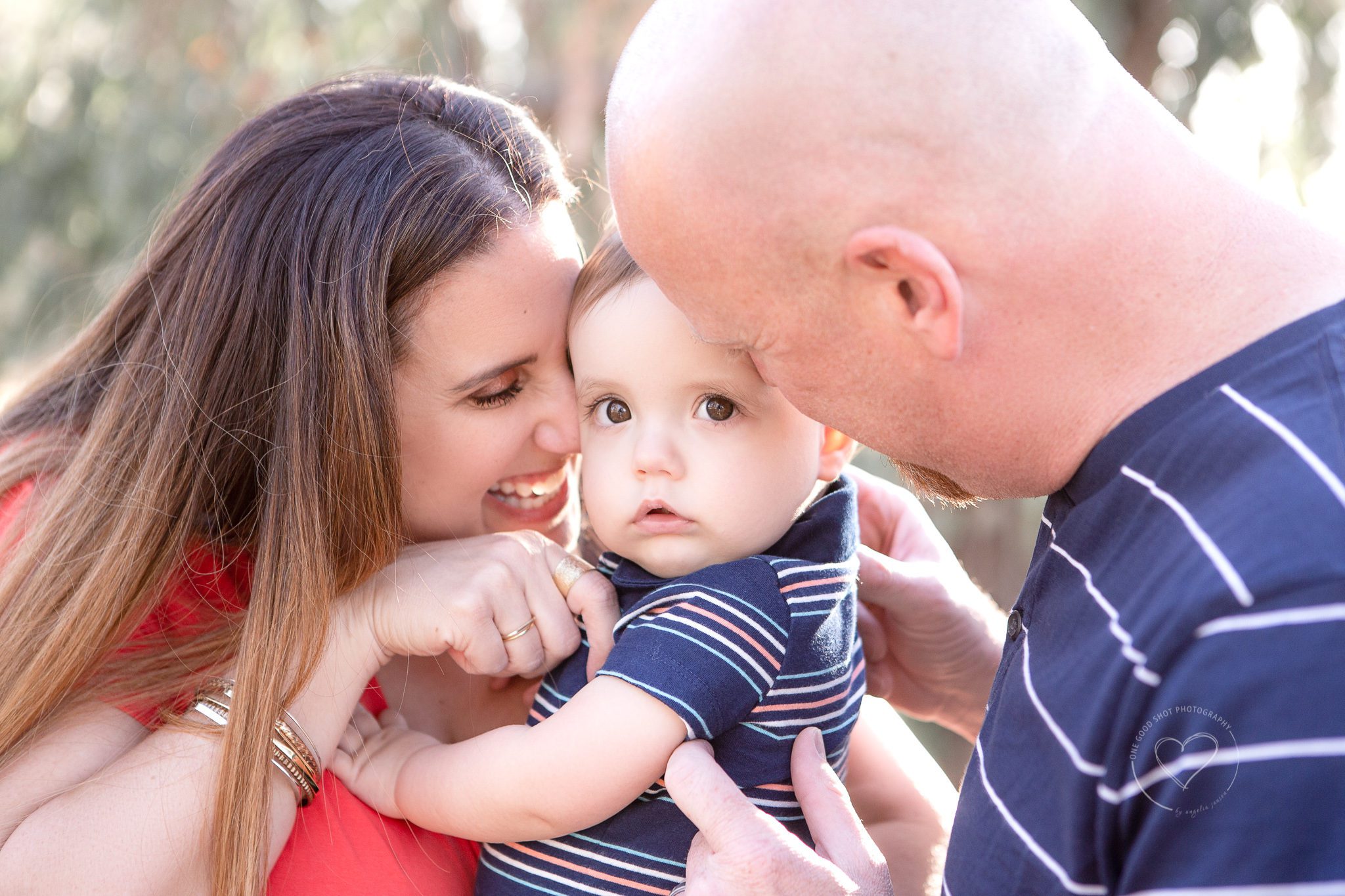 Family Photographer, Mom and dad snuggiling on baby boy, Fresno, One Good Shot Photography