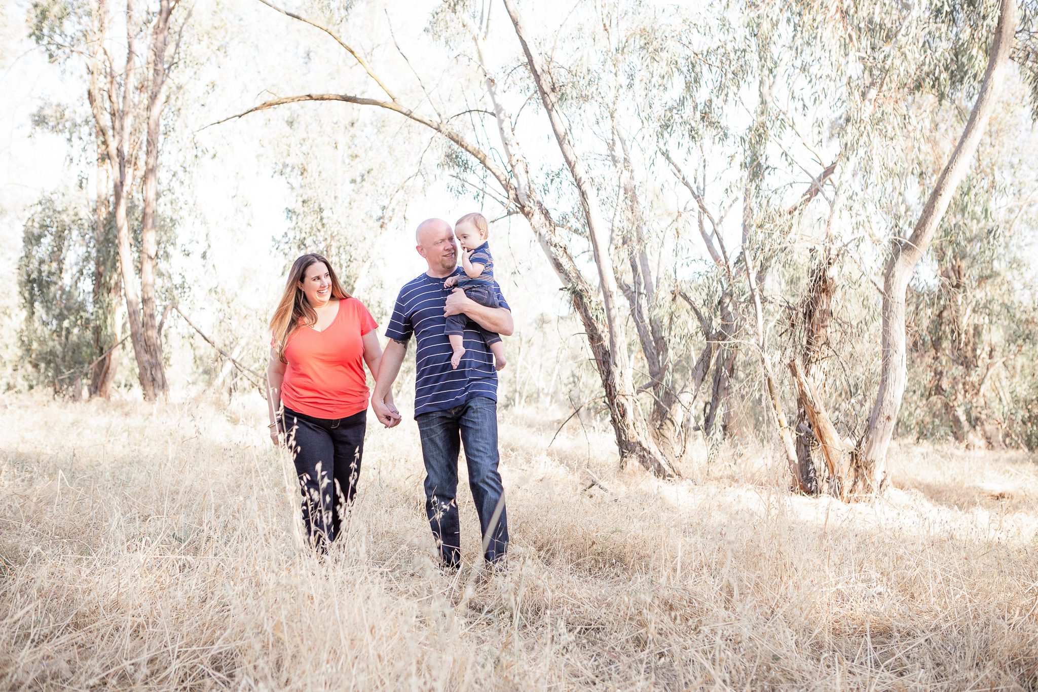 Fresno Family Photographer, Mom, Dad, and Baby walking in a field