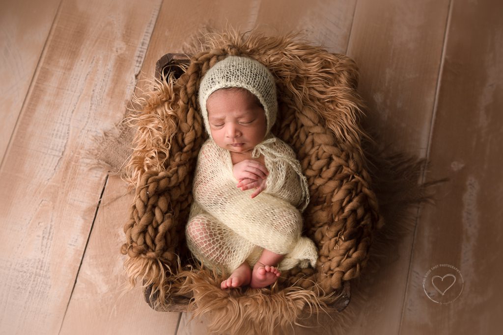fresno newborn photographer, baby wrapped in light yellow Laying on brown fur