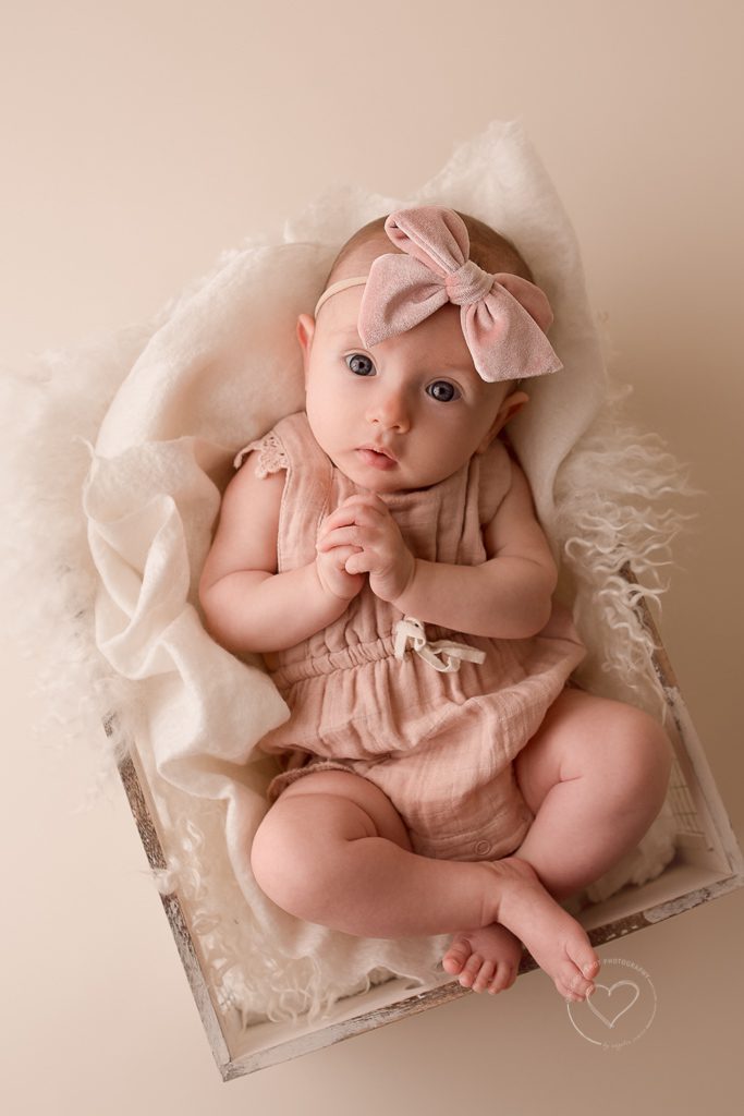 3 month old baby girl milestone photos, pink romper, pink bow, holding hands together, fresno, baby, photographer
