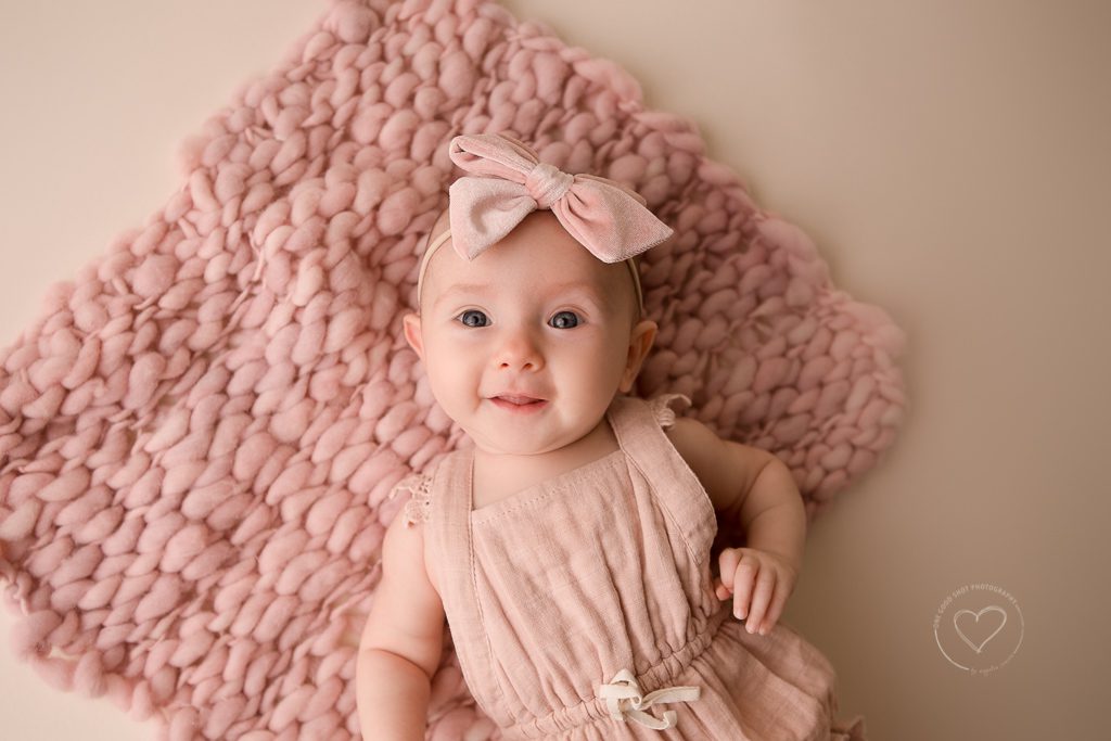 3 month old baby girl milestone photos, pink romper, pink bow, holding hands together, fresno, baby, photographer, smiling