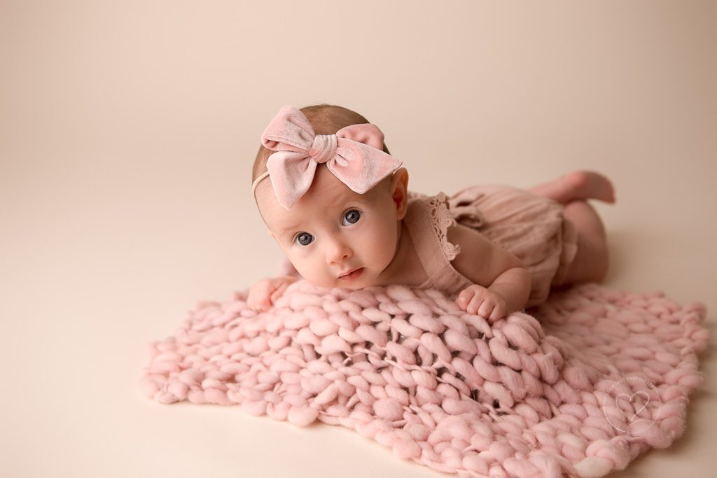 3 month old baby girl milestone photos, pink romper, pink bow, holding hands together, fresno, baby, photographer, tummy time