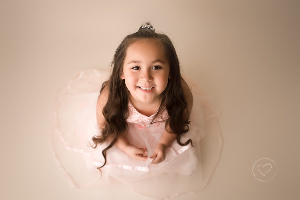 little girl looking up at camera smiling, studio photography, Fresno, Clovis 