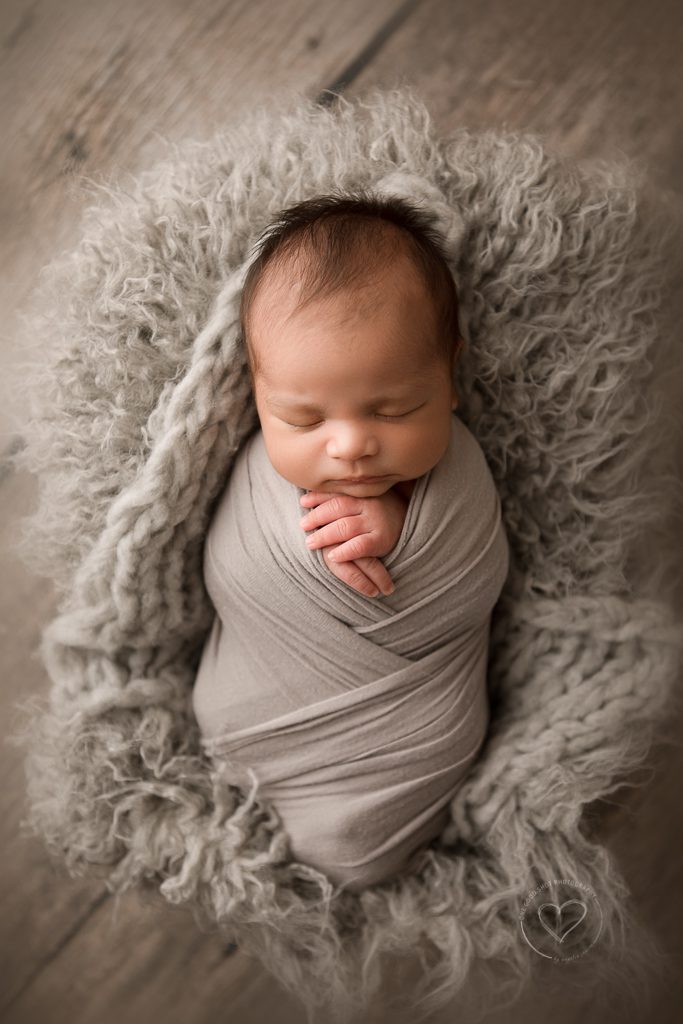 newborn boy photographer, gray wrap, gray layers, hands out