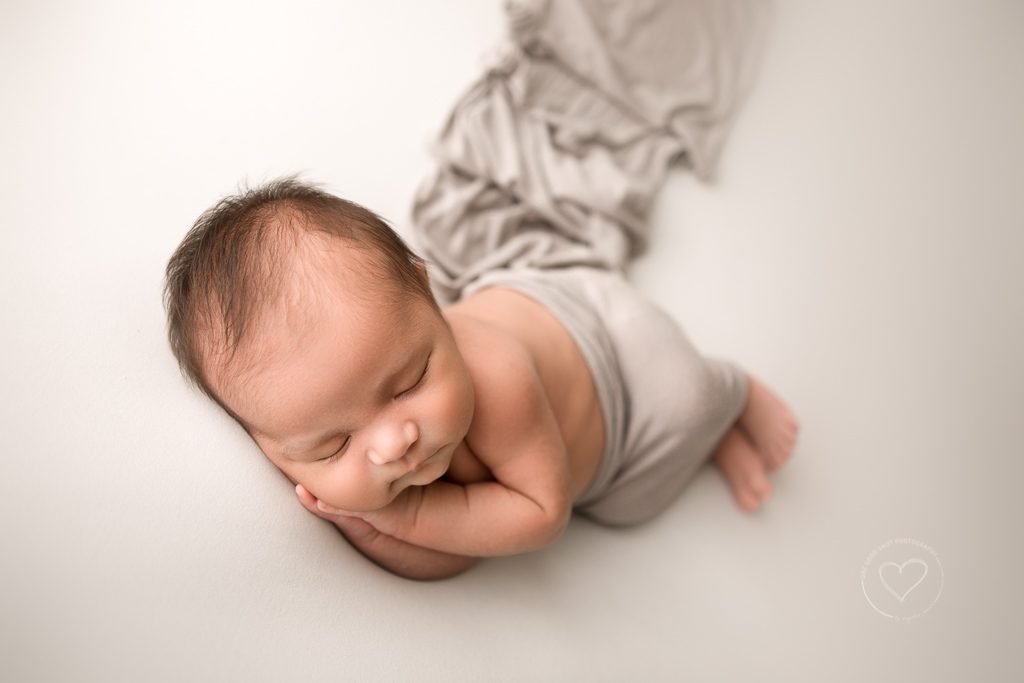 Newborn boy, side lying pose, white backdrop, gray layer, fresno photographer