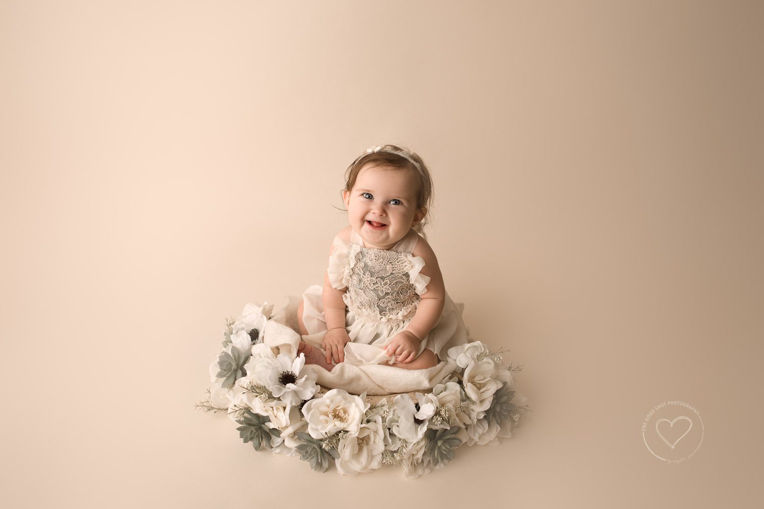 baby girl sitting in bowl with flowers, smiling at camera, 6 month old, milestone session, fresno, clovis, photographer, one good shot photography