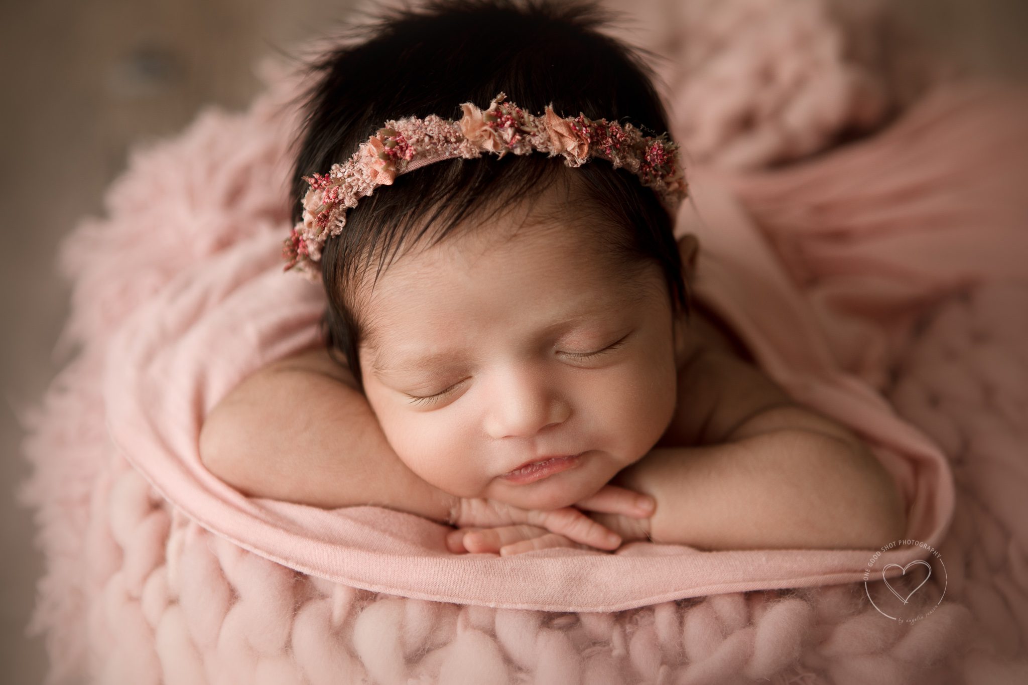 newborn baby girl, head on hands, floral halo, pink props, smile, fresno photographer