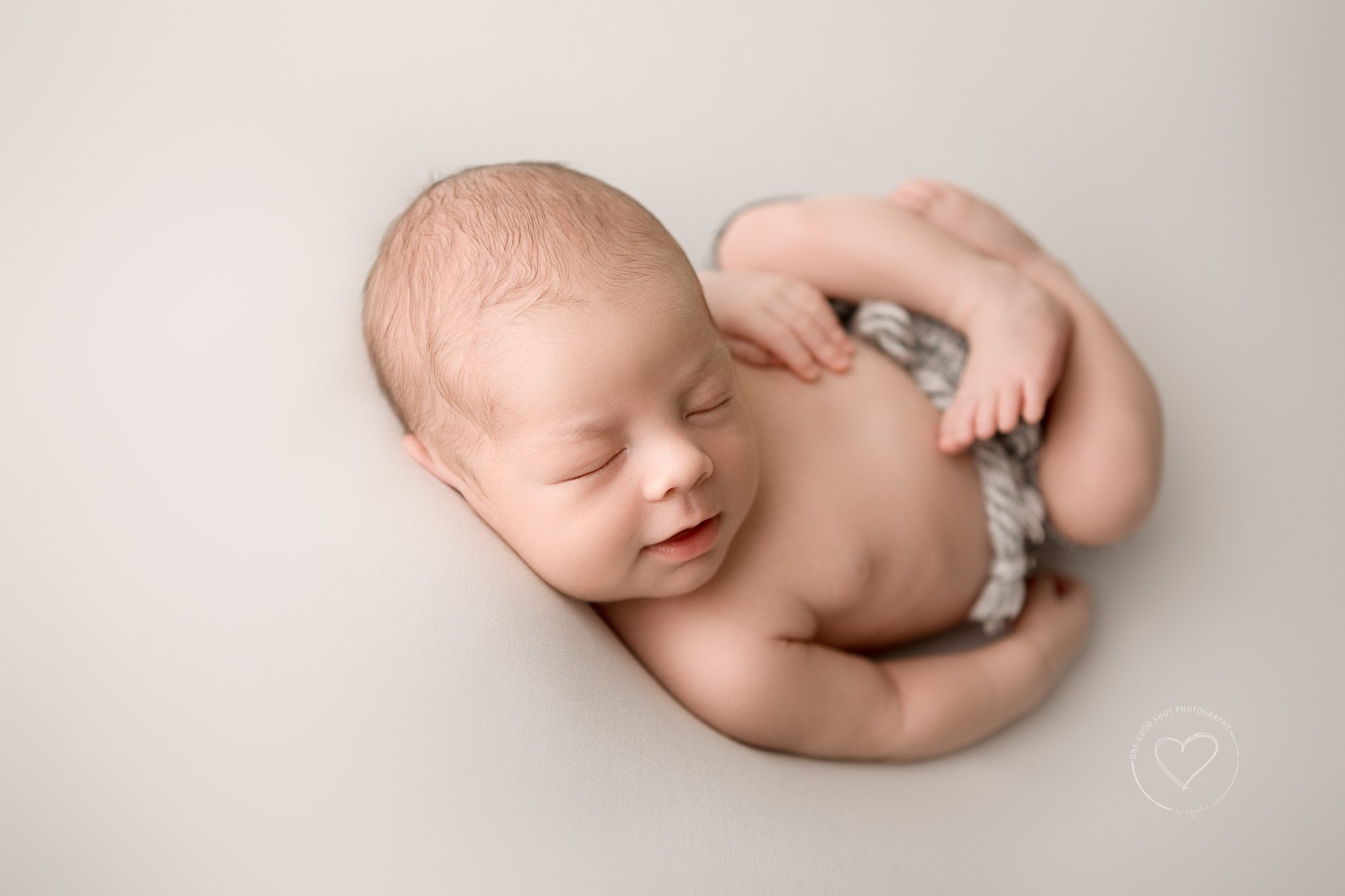 newborn boy wearing gray short, huck finn pose, smiling, fresno photographer, one good shot