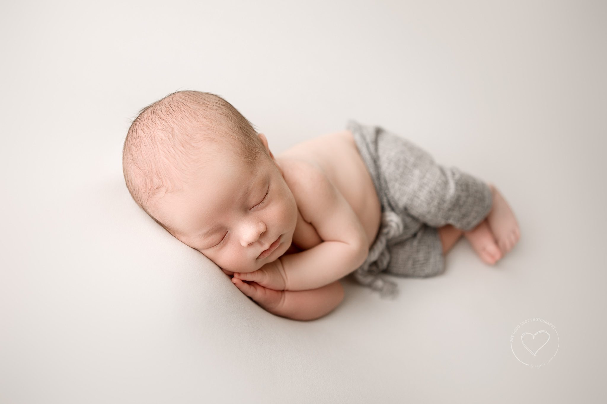 newborn boy wearing gray shorts, side lying pose, fresno photographer, one good shot 