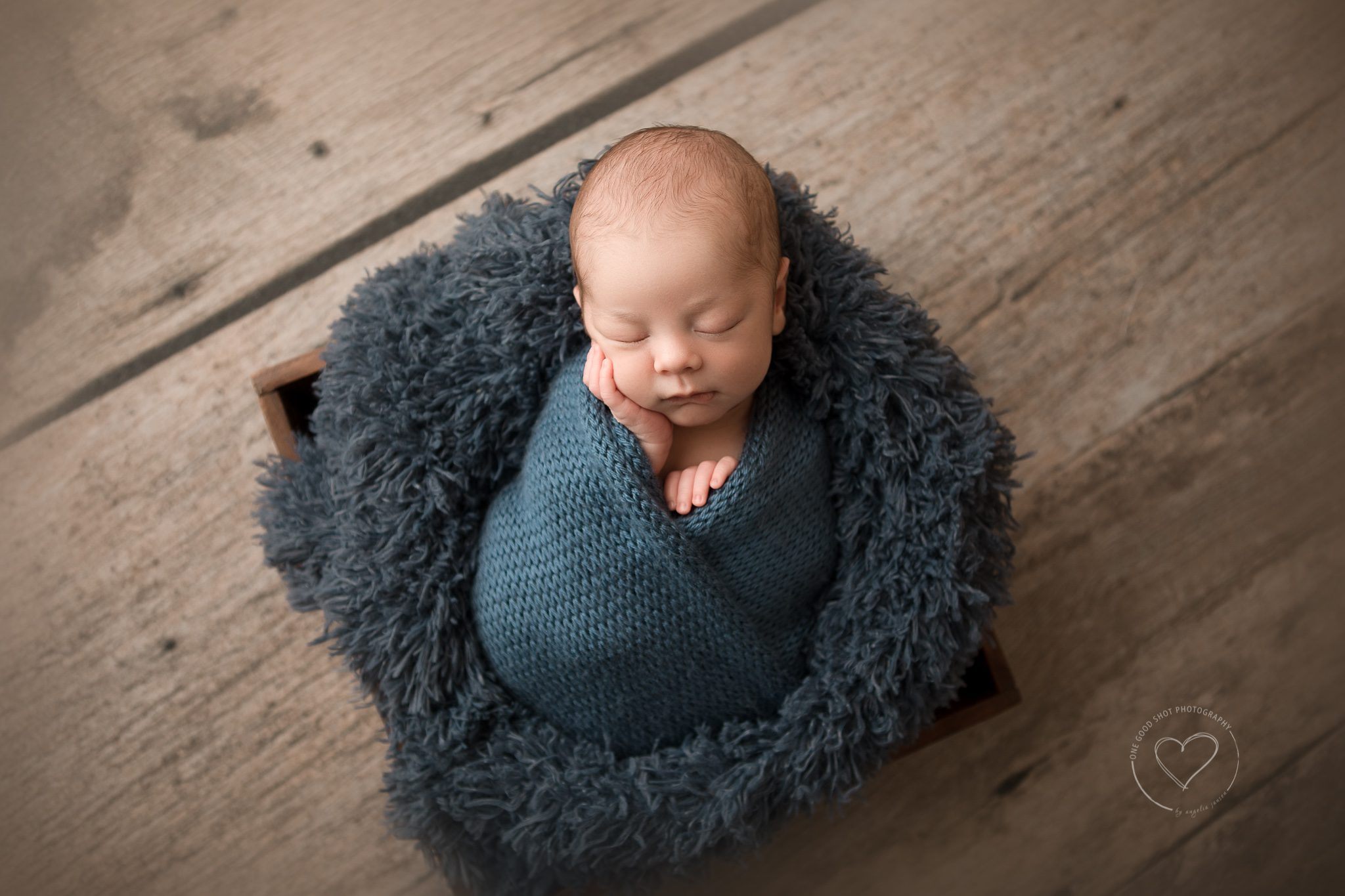 newborn boy wrapped in blue, hand on cheek, fresno, photographer