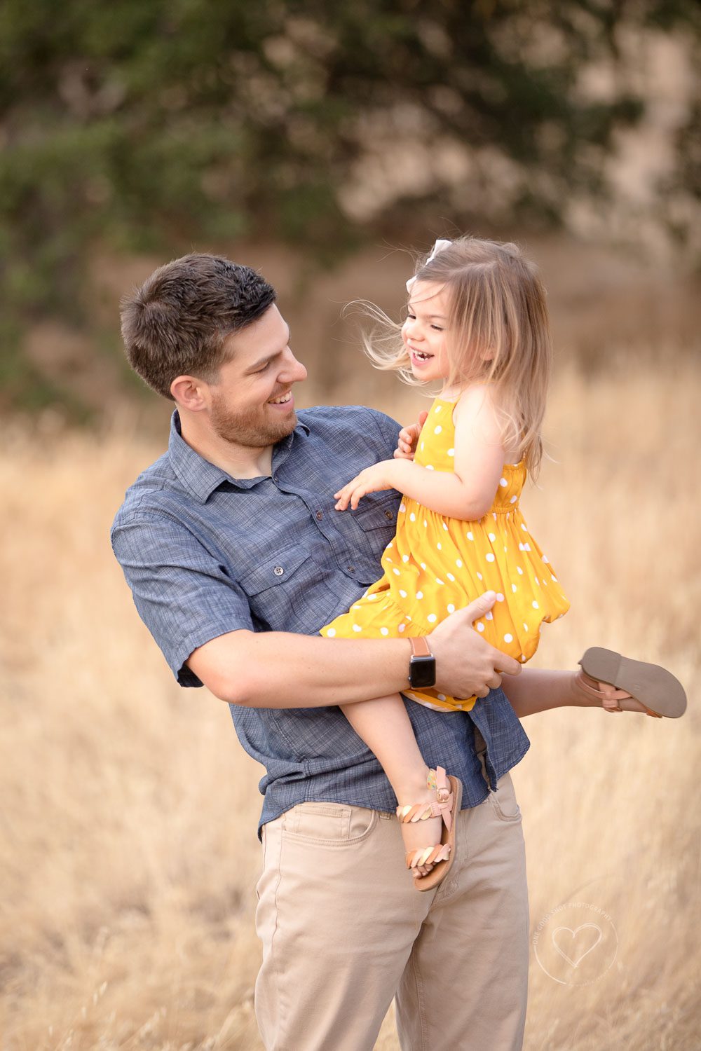 Dad and daughter laughing in a grassy field, Fresno, Clovis, photographer