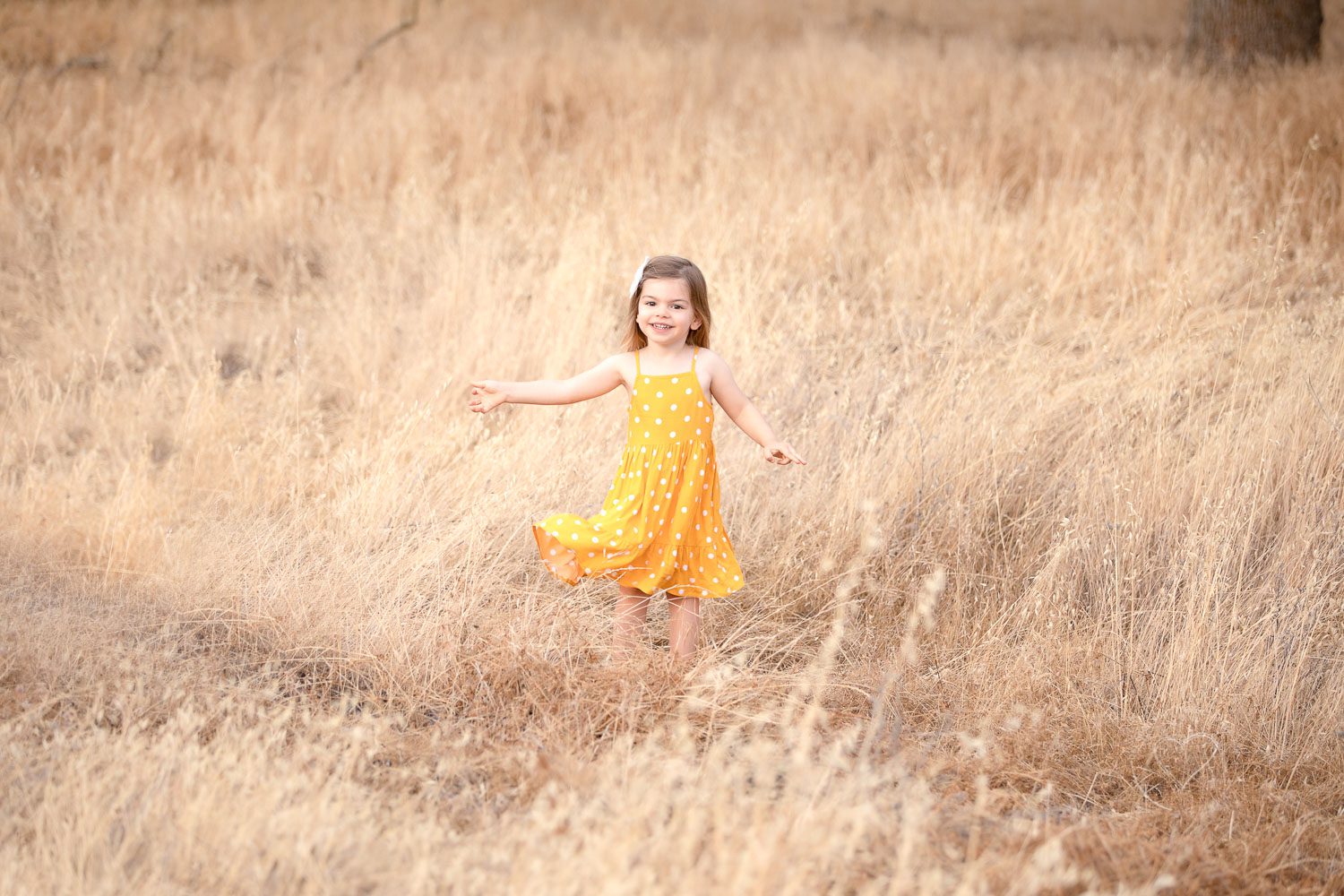 Little girl smiling, grassy foothills, Fresno, Clovis, photographer