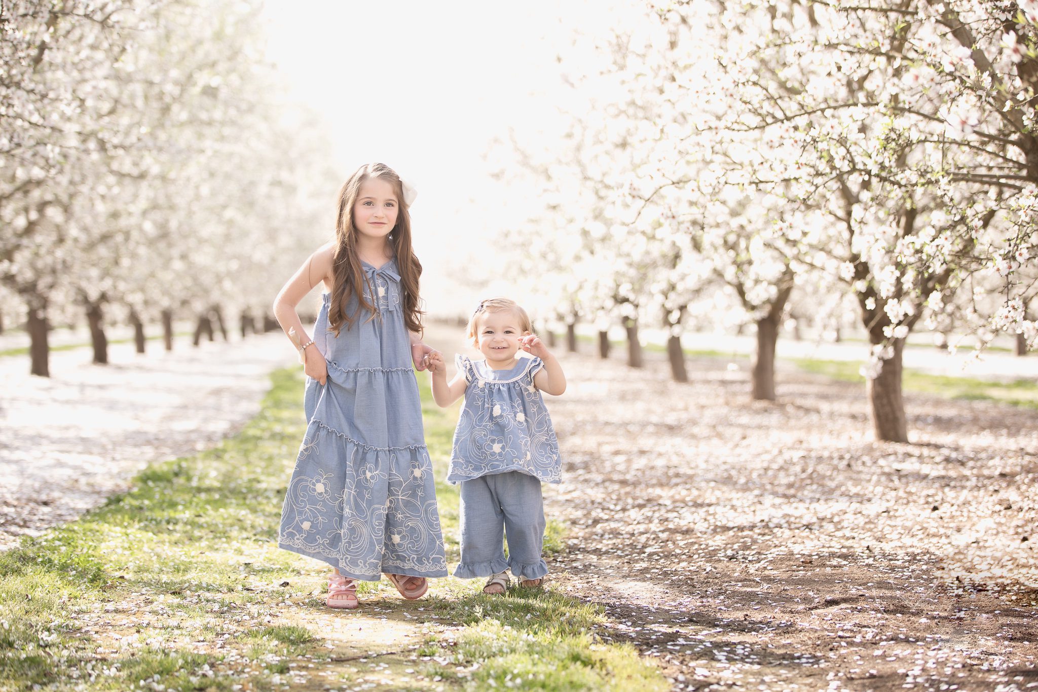 Sisters, holding hands, walking the blossom trail, Fresno Ca