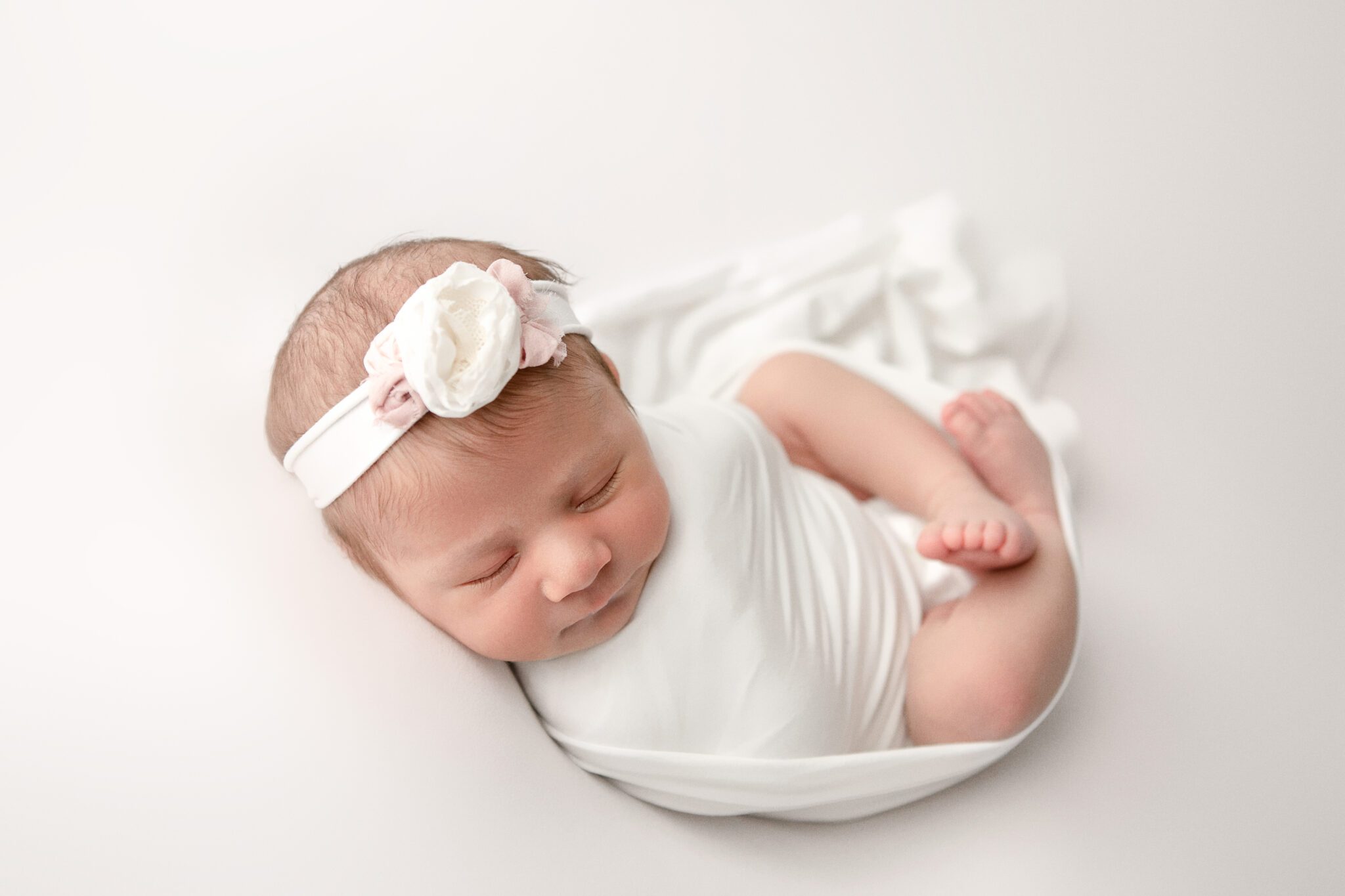 Newborn baby girl wrapped in white fresno california photographer