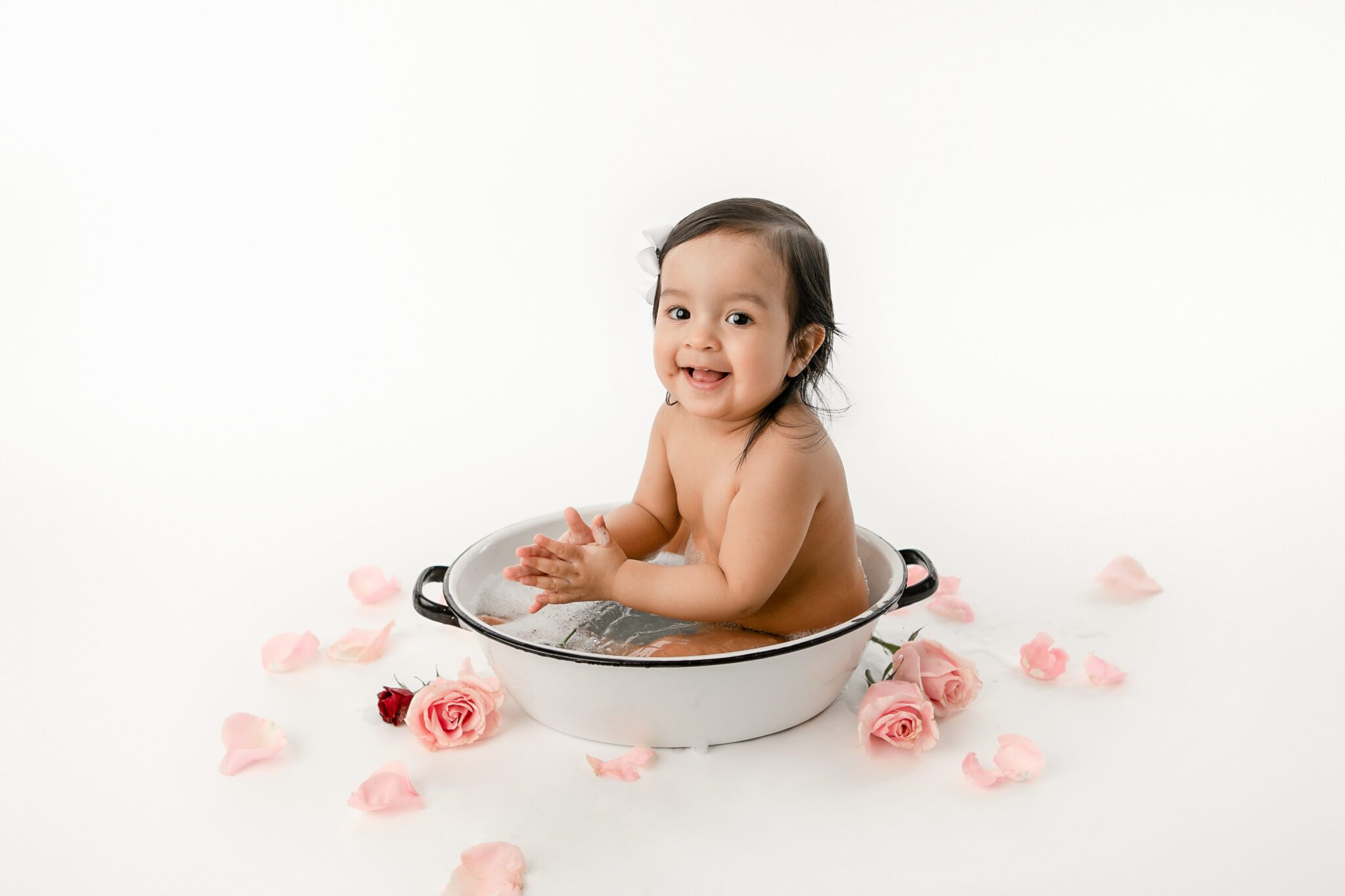 Baby in bathtub with pink flower petals with fresno baby photographer